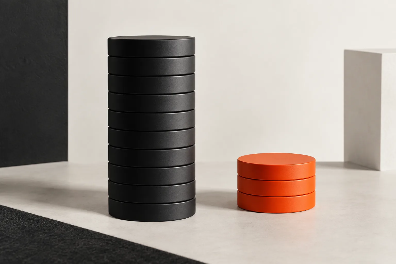A tall stack of black discs next to a low orange stack: lower sourcing costs.