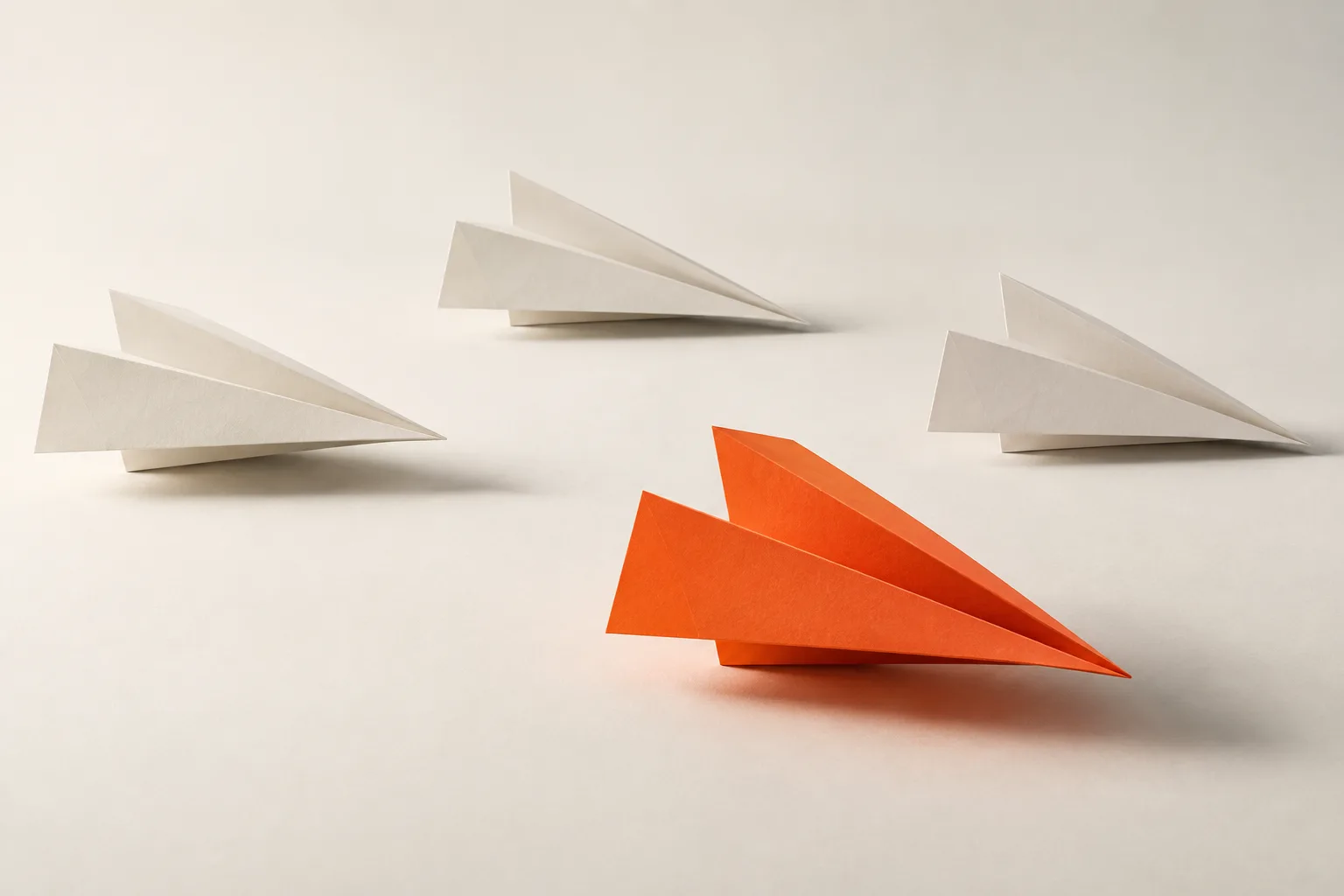 Three white paper planes with an orange one in front: outreach.