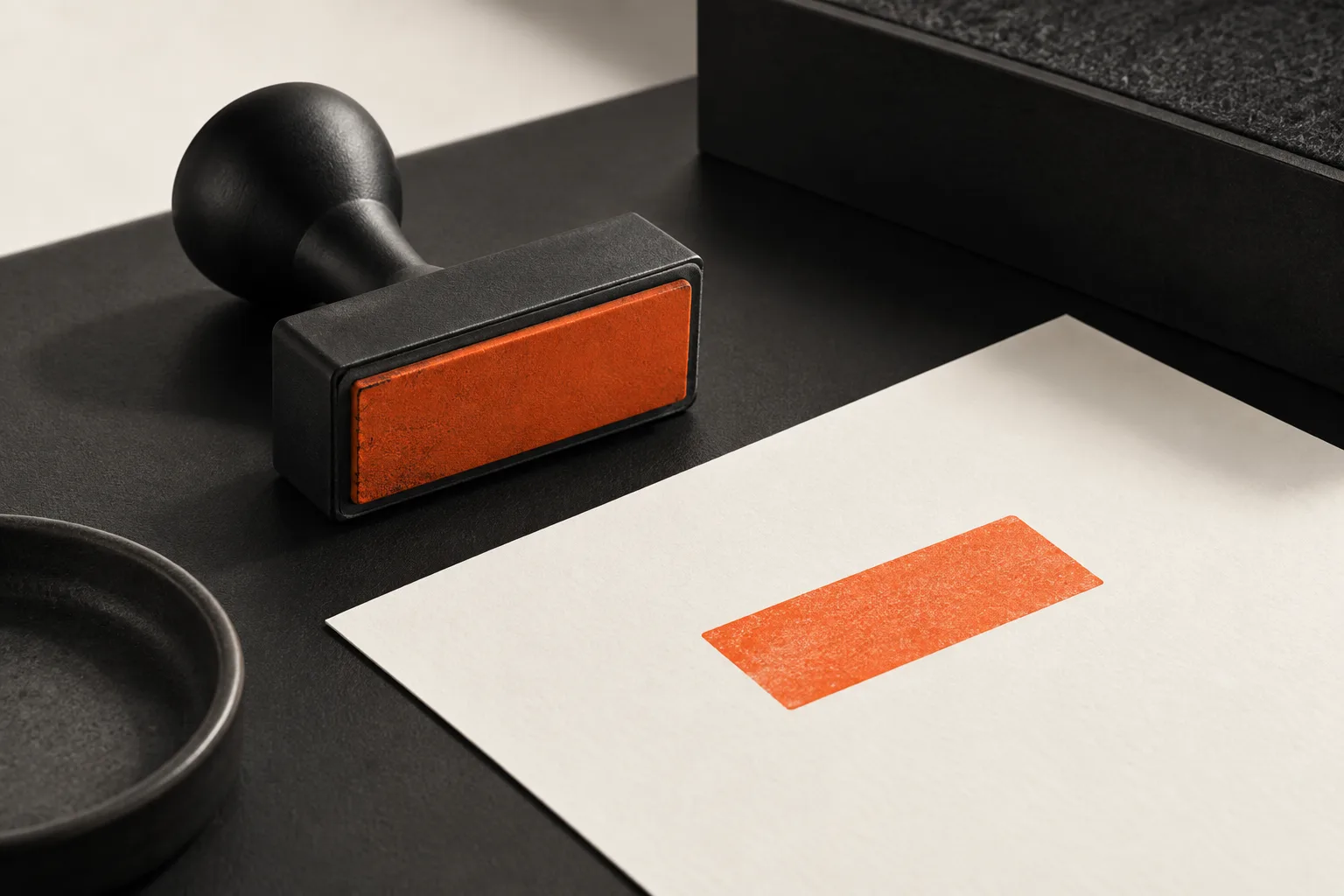 A black rubber stamp next to a sheet with an orange stamp mark: approval.