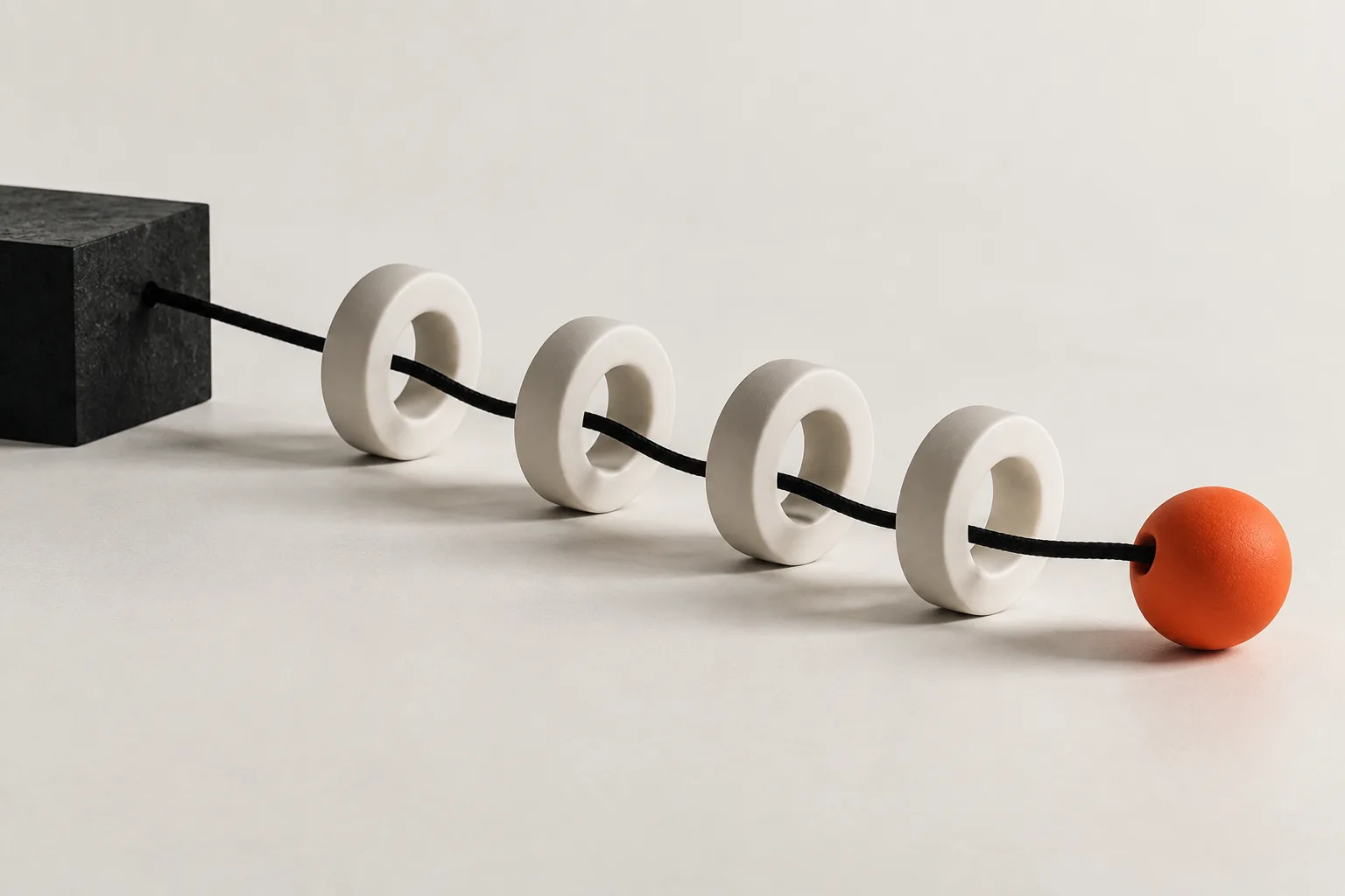 A black thread running through white rings to an orange ball: a follow-up sequence.