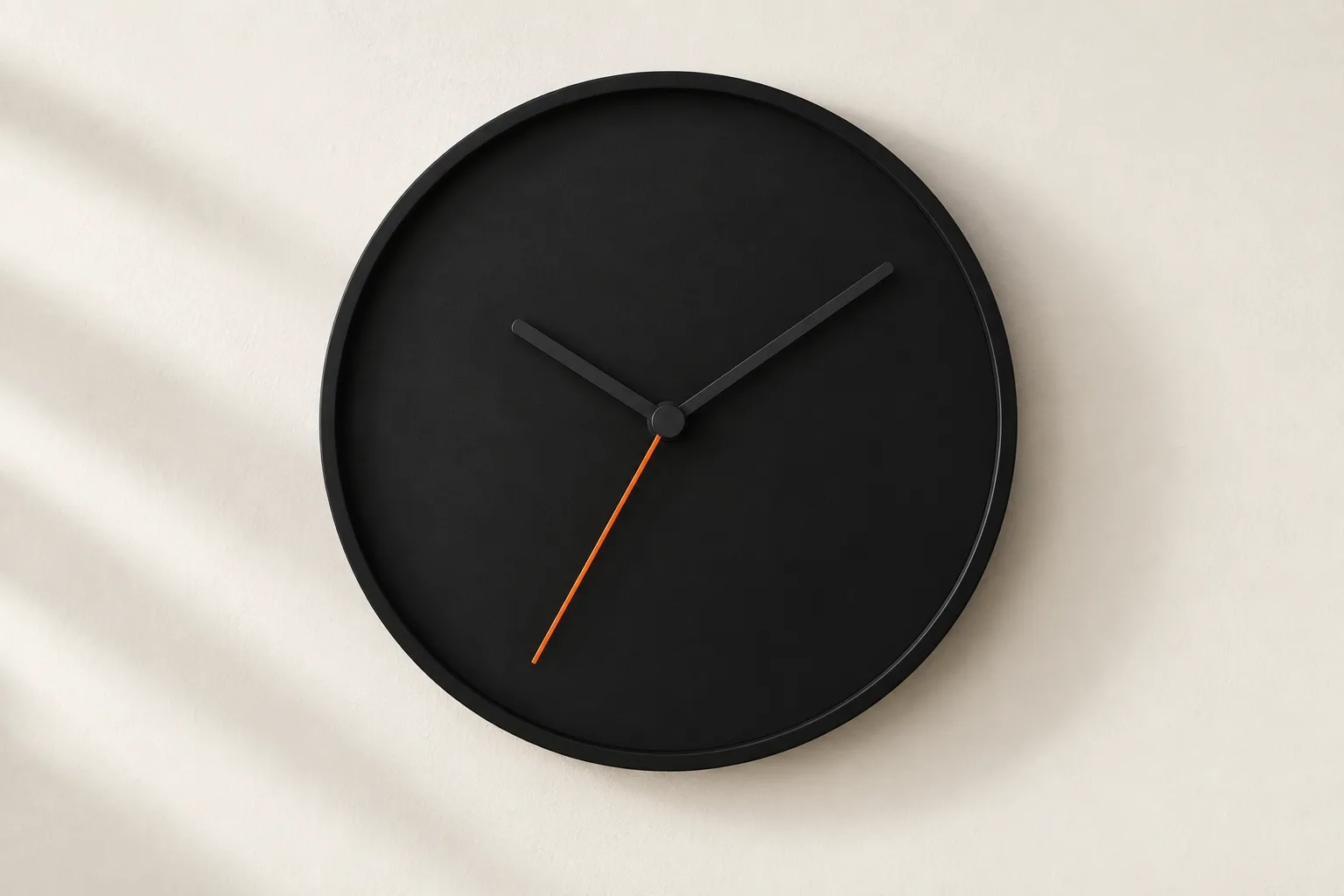 A black wall clock with an orange second hand.