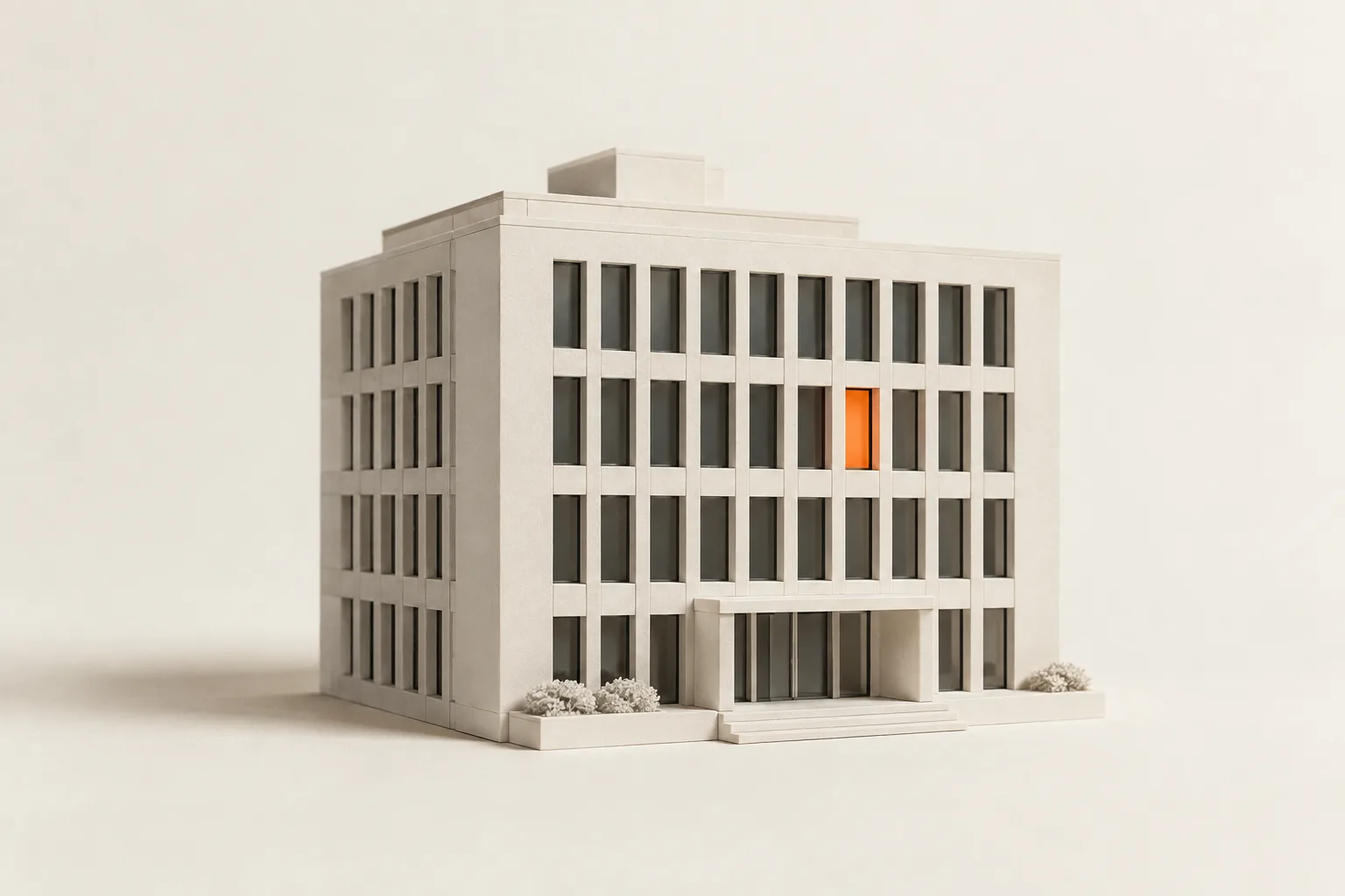 A white scale model of an office building with one orange window.